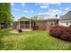 A backyard shows a brick house with a wooden deck, screened-in porch, lawn, and a red Japanese maple tree at 1113 Urban Pl, Charlotte, NC 28209