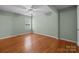 Bright bedroom features hardwood floors, neutral paint, ceiling fan, and a window providing natural light at 1113 Urban Pl, Charlotte, NC 28209