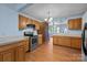 Spacious kitchen area featuring stainless steel appliances, wooden cabinets and a view into the dining area at 1113 Urban Pl, Charlotte, NC 28209