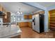 Open layout of kitchen into dining area with stainless steel appliances, wooden cabinetry, and hardwood floors at 1113 Urban Pl, Charlotte, NC 28209
