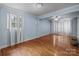 Living room with hardwood floors, a ceiling fan, and large windows for natural light at 1113 Urban Pl, Charlotte, NC 28209
