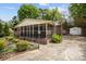 Side view of the charming brick home with a screened-in back porch and a long driveway at 1113 Urban Pl, Charlotte, NC 28209