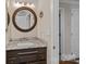 Bathroom vanity with granite counter, round mirror, and modern lighting at 1211 Torrence Cir, Davidson, NC 28036
