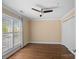 A light-filled bedroom features hardwood floors, a ceiling fan, and large windows with plantation shutters at 1211 Torrence Cir, Davidson, NC 28036