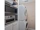 Efficient laundry area with stacked washer/dryer and shelving with built-in microwave oven for convenience at 1211 Torrence Cir, Davidson, NC 28036
