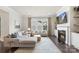 Cozy living room featuring a fireplace, large windows, and a comfortable sofa at 13813 Jacks Ln, Pineville, NC 28134