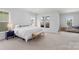 Bright main bedroom featuring large windows, sitting area, and neutral carpet at 13813 Jacks Ln, Pineville, NC 28134