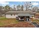 This backyard features an outdoor patio with seating and mature trees at 140 Wandering Ln, Bessemer City, NC 28016