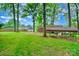 Large backyard featuring a covered shelter, mature trees, and well-maintained lawn at 1409 Sherwood Dr, Kannapolis, NC 28081