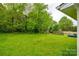 Lush backyard with a large green lawn, mature trees, and a storage shed at 1581 Arborgate Dr, Rock Hill, SC 29732