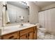 Bright bathroom featuring a single sink vanity and a shower-tub with a white shower curtain at 1581 Arborgate Dr, Rock Hill, SC 29732