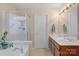 Bathroom with a glass enclosed shower, soaking tub, and double sink vanity at 16524 Kettlewell Ln, Charlotte, NC 28277
