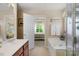Bathroom featuring a soaking tub, glass shower, and access to the bedroom at 16524 Kettlewell Ln, Charlotte, NC 28277