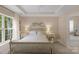 Bedroom with a white wood frame bed and side tables, large window, and tray ceiling at 16524 Kettlewell Ln, Charlotte, NC 28277