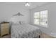 Cozy bedroom with ceiling fan, large window with blinds, and patterned bedspread at 16524 Kettlewell Ln, Charlotte, NC 28277