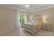 Bedroom with a white wood frame bed and side tables, large window, and ceiling fan at 16524 Kettlewell Ln, Charlotte, NC 28277