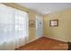 Bright foyer featuring hardwood floors, a window with sheer curtains, and a white front door at 16524 Kettlewell Ln, Charlotte, NC 28277