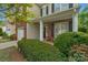 Welcoming front porch with brick and siding accents, flowering bushes and charming decor at 16524 Kettlewell Ln, Charlotte, NC 28277