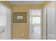 Bright hallway featuring neutral carpet, light yellow walls, and decorative wall mirror at 16524 Kettlewell Ln, Charlotte, NC 28277