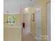Upstairs hallway with neutral carpet and paint, window and access to other rooms at 16524 Kettlewell Ln, Charlotte, NC 28277