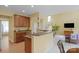 Open kitchen and living space with bar top, wooden cabinets, and white staircase at 16524 Kettlewell Ln, Charlotte, NC 28277
