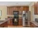 Traditional kitchen with wood cabinets, stainless steel refrigerator, and dark countertops at 16524 Kettlewell Ln, Charlotte, NC 28277