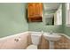 A half bathroom with wood cabinets, a small sink, and pastel green walls at 173 Chestnut Grove Rd, Statesville, NC 28625