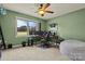 This is a green bedroom with a ceiling fan, and a workstation for multiple monitors at 173 Chestnut Grove Rd, Statesville, NC 28625