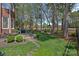 Expansive backyard featuring a stone patio, outdoor grill, and manicured greenery at 18418 Turnberry Ct, Davidson, NC 28036