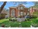 Landscaped backyard view of the beautiful brick home showcasing a stone patio with dining at 18418 Turnberry Ct, Davidson, NC 28036