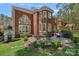 Charming backyard featuring an immaculate lawn, stone patio, and an elegant brick home at 18418 Turnberry Ct, Davidson, NC 28036