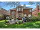 Extensive backyard view of the brick home showcasing a stone patio and outdoor seating area at 18418 Turnberry Ct, Davidson, NC 28036