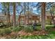 Picturesque backyard view of the brick home with lush landscaping and a serene fountain at 18418 Turnberry Ct, Davidson, NC 28036