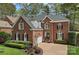 Elegant brick home with a three-car garage, complemented by professional landscaping and a circular driveway at 18418 Turnberry Ct, Davidson, NC 28036