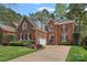 Classic brick home featuring arched windows, black shutters, manicured landscaping, and a welcoming driveway at 18418 Turnberry Ct, Davidson, NC 28036