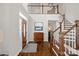 Grand foyer with hardwood floors, a staircase, and a statement cabinet that create a welcoming entrance at 18418 Turnberry Ct, Davidson, NC 28036