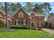 Charming two-story brick home with manicured lawn, mature trees, and classic architectural details at 18418 Turnberry Ct, Davidson, NC 28036