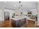 Modern kitchen featuring a large island, stainless steel appliances, and an open layout leading to the living room at 18418 Turnberry Ct, Davidson, NC 28036