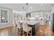 Spacious kitchen featuring a large island, white cabinets, hardwood floors, and modern stainless appliances at 18418 Turnberry Ct, Davidson, NC 28036