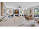 Well-lit living room with a fireplace, plush seating, a ceiling fan, and multiple windows at 18418 Turnberry Ct, Davidson, NC 28036