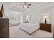 Bright bedroom with a tray ceiling, large windows, a sitting area, and neutral decor at 18418 Turnberry Ct, Davidson, NC 28036