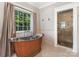 Bathroom featuring a copper standalone tub and walk-in shower with marble tile at 2030 Radcliffe Ave, Charlotte, NC 28207
