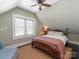 Cozy bedroom with a classic wooden bed frame, plush bedding, and a ceiling fan above at 2030 Radcliffe Ave, Charlotte, NC 28207