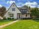 Charming two-story home with a manicured lawn, stone walkway, and beautiful landscaping at 2030 Radcliffe Ave, Charlotte, NC 28207