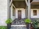 Inviting covered front porch with stone floors, decorative columns, and an ornate wooden door at 2030 Radcliffe Ave, Charlotte, NC 28207