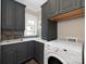 Well-equipped laundry room with modern washer, elegant cabinets, and stylish backsplash at 2030 Radcliffe Ave, Charlotte, NC 28207