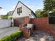 Charming outdoor kitchen with brick surround, stone patio, stainless grill, and adjacent two-car garage at 2030 Radcliffe Ave, Charlotte, NC 28207
