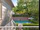 Secluded in-ground pool area featuring mature trees and lush landscaping, visible from the upper balcony at 2030 Radcliffe Ave, Charlotte, NC 28207