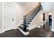 Elegant staircase with dark wood steps, ornate black railings, and a contrasting light wall color at 2030 Radcliffe Ave, Charlotte, NC 28207