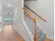 Welcoming entryway with hardwood floors, staircase with carpeted steps and views to living area at 2032 Summey Ave, Charlotte, NC 28205